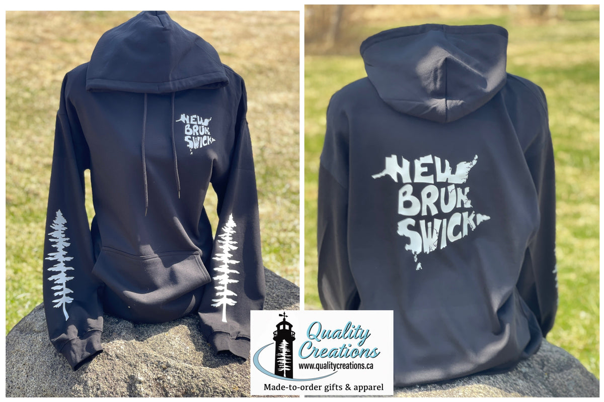A black pullover hoodie shown from the back on a rock outdoors, with white printed graphics reading 'New Brunswick' ' plus tree silhouettes on the sleeves. A second view of the same hoodie appears beside it, and a 'Quality Creations' logo card is overlaid at the bottom.