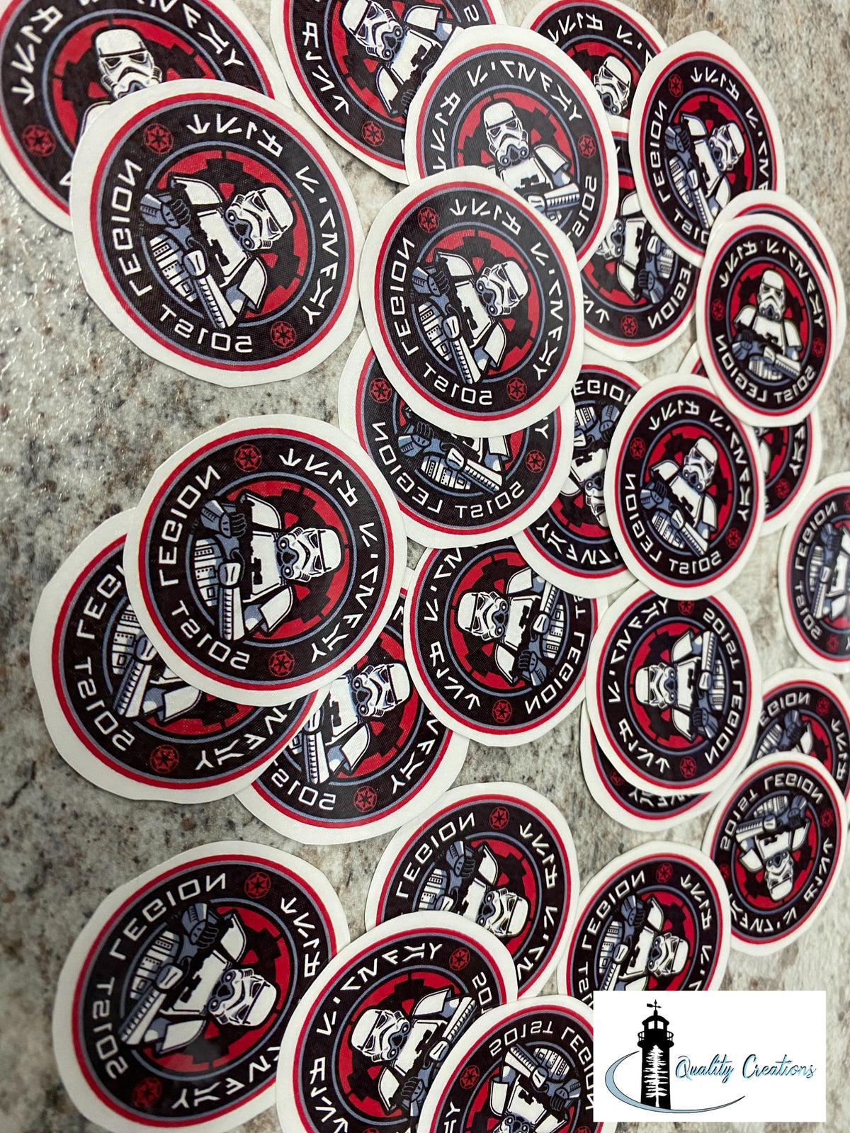 A pile of oval stickers featuring a Stormtrooper illustration with the text 'SECTOR 7' and '2018 STAR WARS LEGENDS REBORN' on a textured gray background.