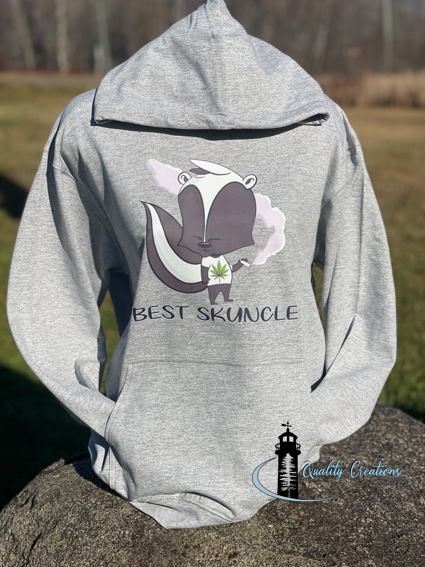 Custom grey hoodie featuring a Best Skuncle design with cartoon skunk holding flowers by Quality Creations