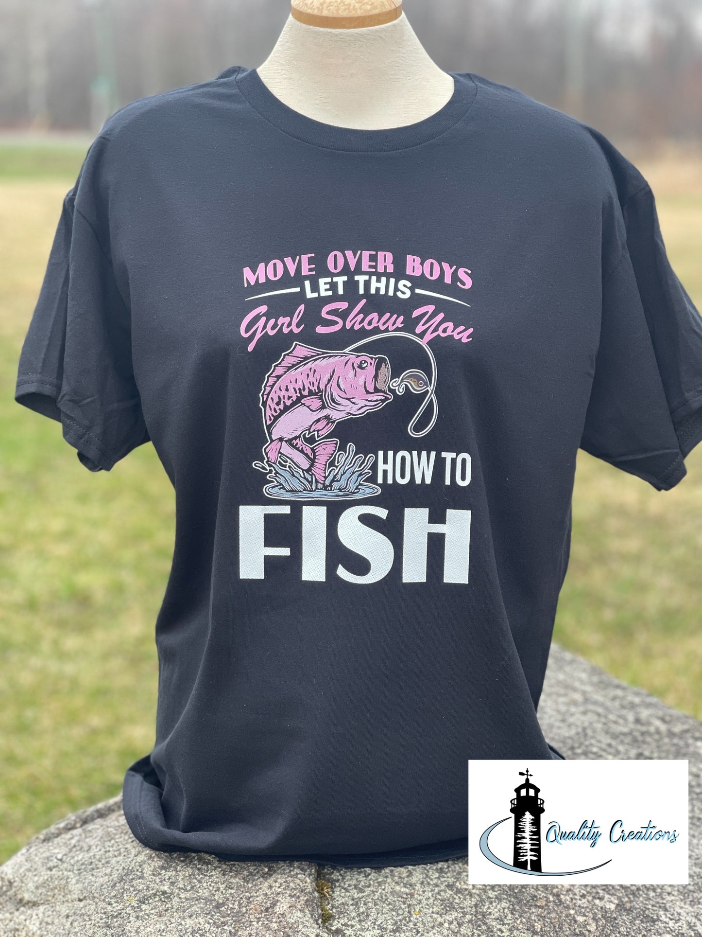 Black women’s unisex fishing shirt with the phrase “Move Over Boys Let This Girl Show You How to Fish,” displayed on a mannequin outdoors in Salisbury, near Moncton, New Brunswick.