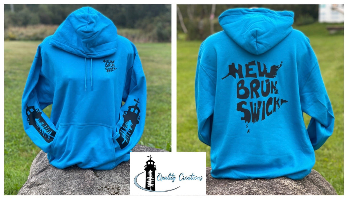 Sapphire blue New Brunswick hoodie with black lighthouse sleeve graphics, small chest logo, and large New Brunswick design on back, displayed outdoors in Salisbury, New Brunswick.