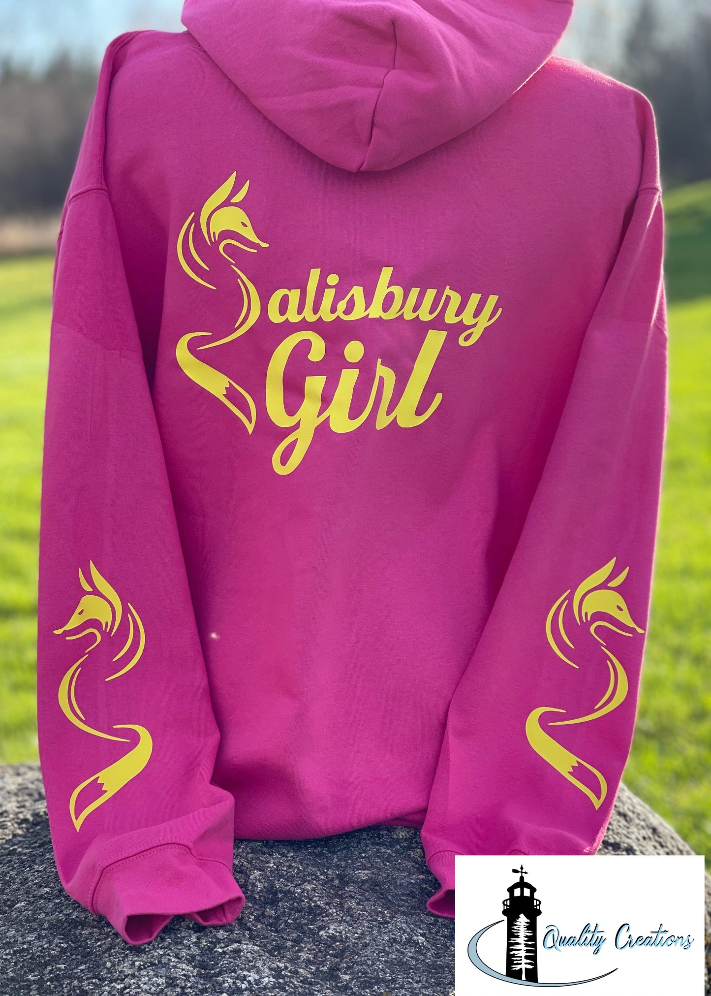 Sangria pink Salisbury Girl pullover hoodie with bright yellow text and fox designs on the sleeves. Perfect for locals from Salisbury, Moncton, Sussex, and Hampton in New Brunswick.