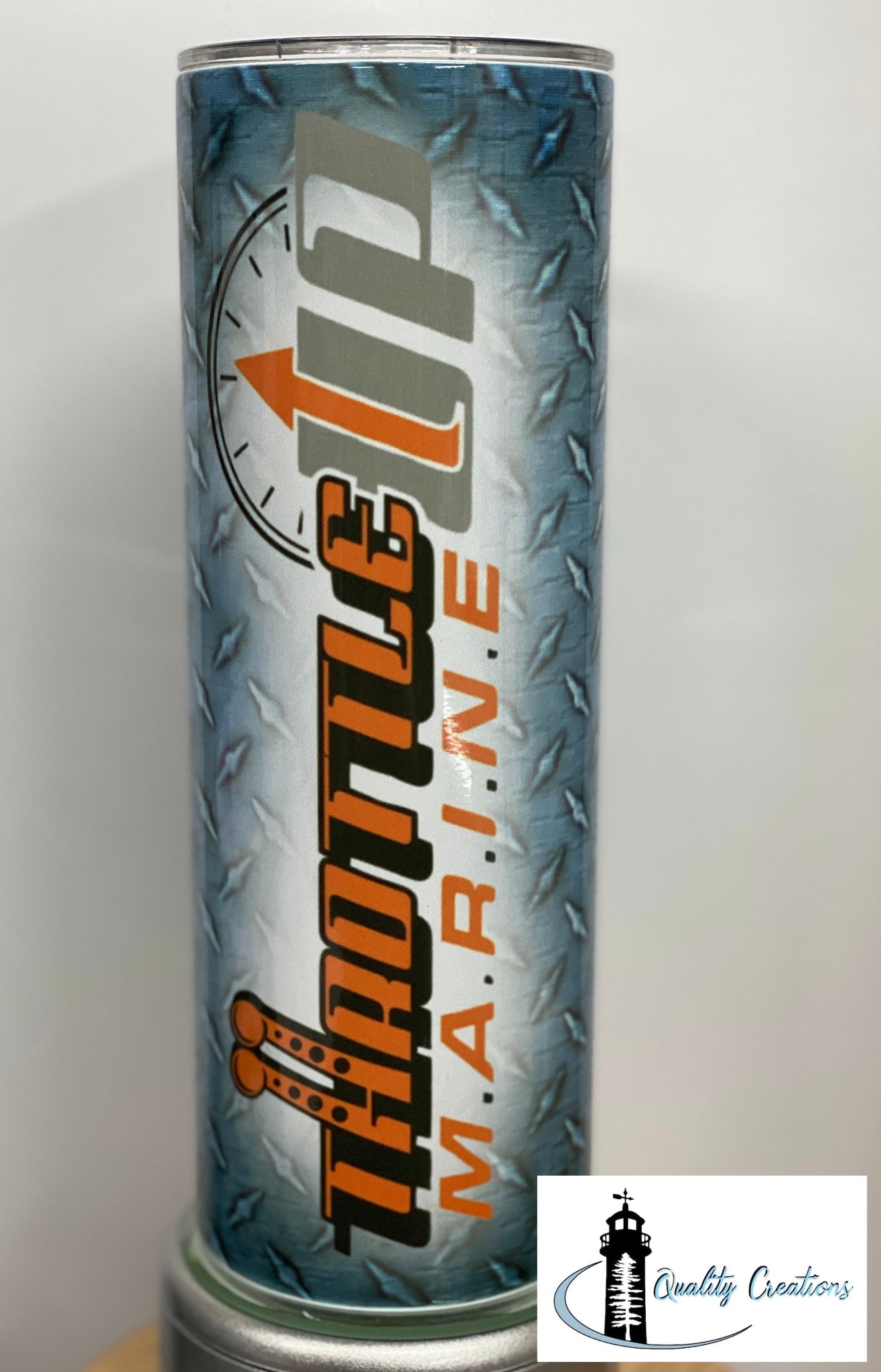 A cylindrical metal tumbler with a diamond plate pattern background, featuring the words 'Throttle Up MARINE' in bold orange and black lettering. The tumbler is shown standing upright, with a 'Quality Creations' logo overlay in the bottom right corner.
