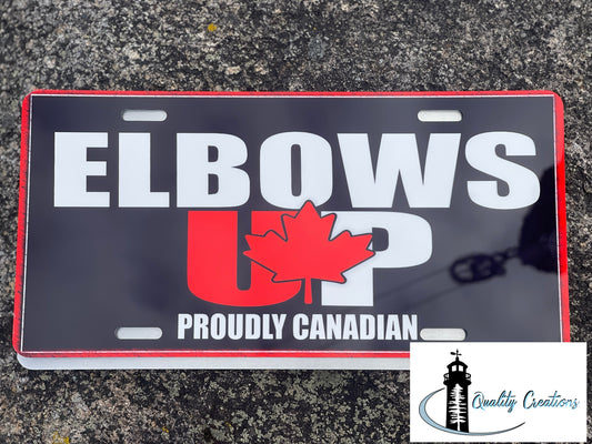 lbows Up Proudly Canadian front license plate with red maple leaf design, created by Quality Creations, displayed on a textured outdoor surface. Moncton, Salisbury, New Brunswick, Canada, Ontario 