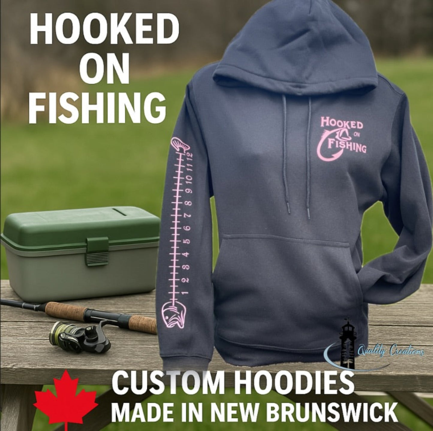 Black hoodie with a pink ‘Hooked on Fishing’ graphic and fish ruler down the sleeve, displayed on a mannequin outdoors next to a green tackle box and fishing rod. Text on the image reads: Hooked on Fishing – Custom Hoodies Made in New Brunswick, Salisbury, Moncton, qalitycreations247, Ontario 