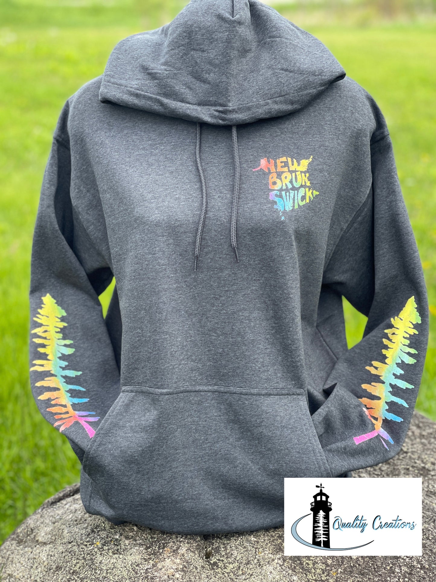 Dark Heather Grey New Brunswick hoodie featuring colourful New Brunswick chest logo and rainbow pine tree sleeve graphics, custom apparel made in Salisbury, New Brunswick, Canada.