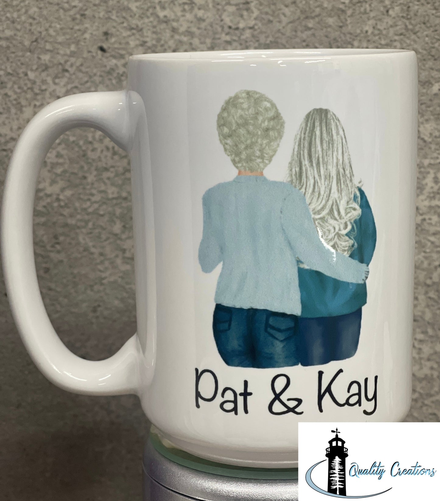 15oz White mug with a custom illustration of two women from behind, arms around each other, with the names Pat & Kay below