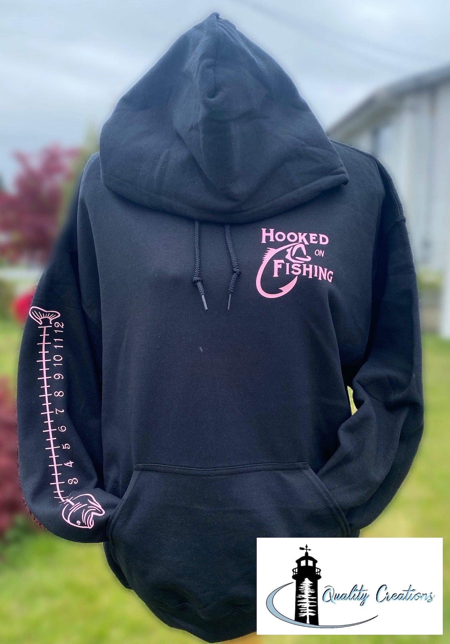 fish measuring on arm with pink font on front with hooked on fishing quality creations canada
